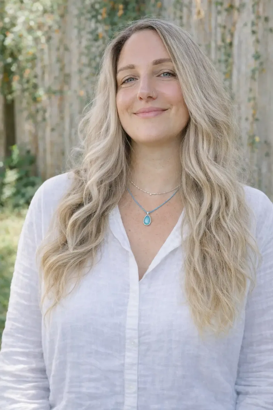 Dr. Sophia Santamaria smiling outdoors among trees in a soft green setting